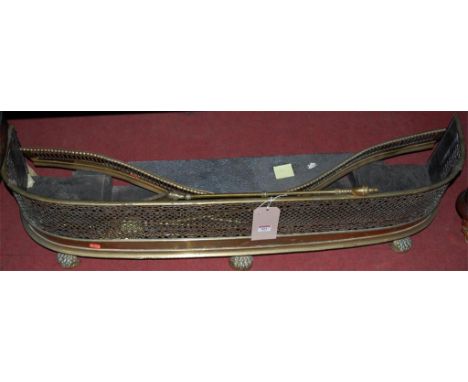A late Victorian pierced brass fire fender, together with one other serpentine example and a collection of fire tools (6)
