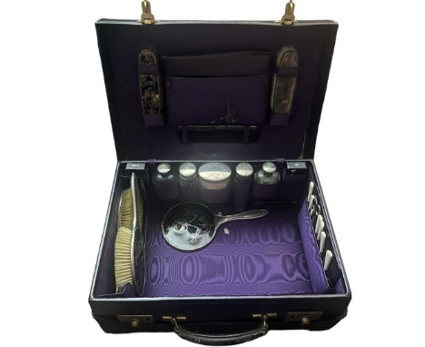 An Edwardian, aubergine purple textured leather travel vanity case with writing set to include hallmarked silver brushes with