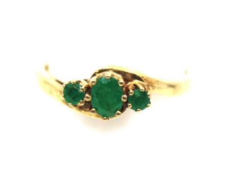9ct Yellow Gold Emerald Three Stone Ring.  The centre Oval Brilliant Cut Emerald measures approx. 6mm x 4mm. The two side Rou