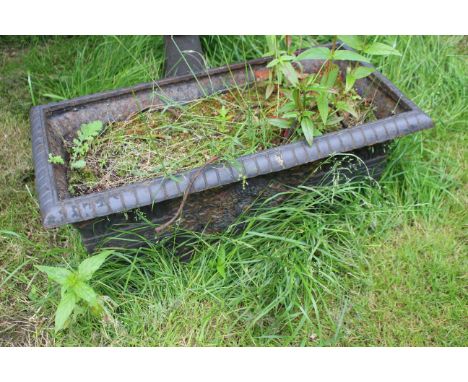 A cast iron garden trough planter with floral decorated sides. Approximately 72cm long, 36cm wide and 33cm high.