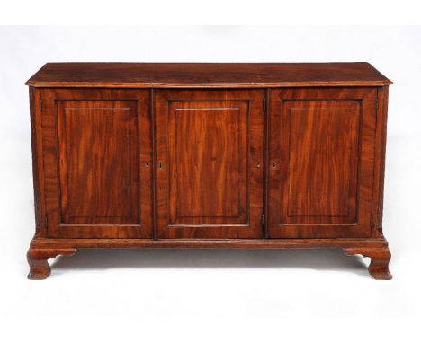 A George III mahogany library cabinet, circa 1780, the rectangular top with moulded edge, above three panelled doors, the pai
