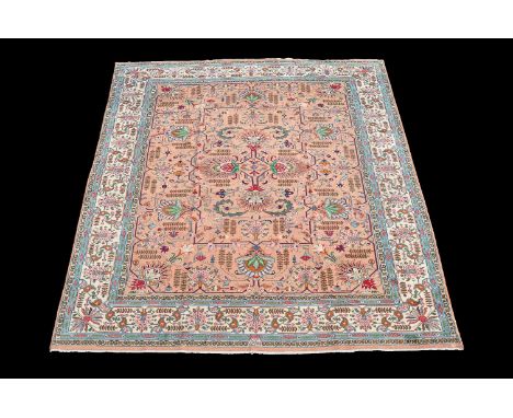 A Tabriz carpet, signed Javan, the pale puce field decorated in polychrome with stylised flowerheads and geometric foliate br