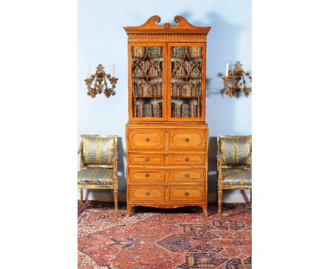 ϒ A Regency satinwood and kingwood crossbanded secretaire bookcase, circa 1815, the twin scroll pediment incorporating marque