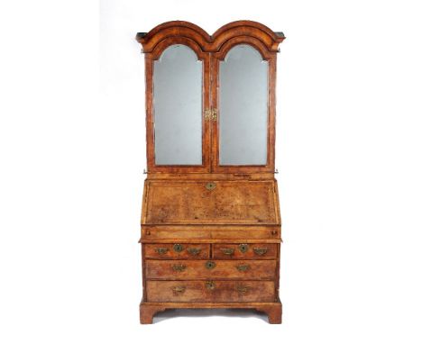 A Queen Anne walnut, burr-walnut and feather banded bureau cabinet, circa 1710, the moulded 'double domed' pediment above a p