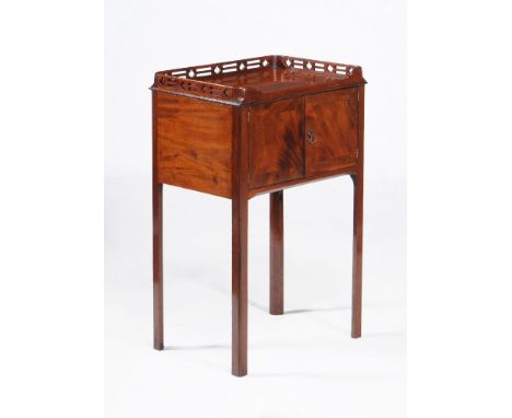 A George III mahogany pot cupboard, attributed to Thomas Chippendale, circa 1770, the rectangular top with a pierced three qu