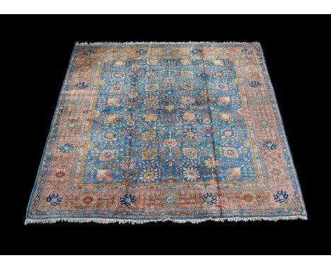A Tabriz carpet, the blue field decorated with an overall design of flowerheads and foliate branches, the burnt orange border