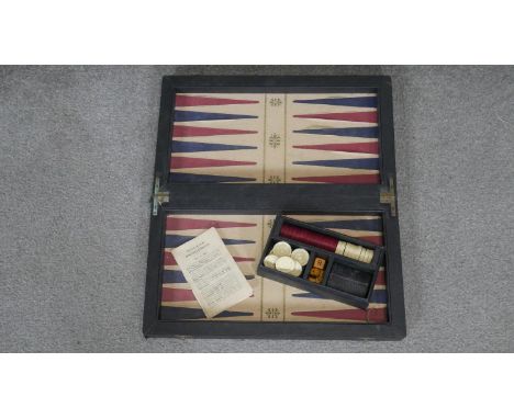 A vintage backgammon board with leather effect interior, pieces, die and instruction booklet. 50x43 