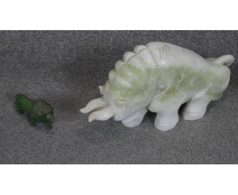 A large carved Chinese jade bull sculpture with engraved floral motifs along with a carved green hardstone lion. 