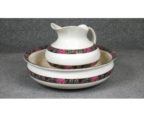 A Victorian ceramic jug and wash bowl with stylised floral design. D.41cm 
