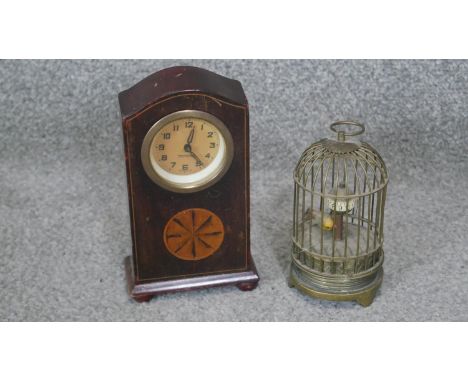 A vintage Japanese brass birdcage clock with plastic bird and a walnut veneered mantle clock with inlaid decoration. 