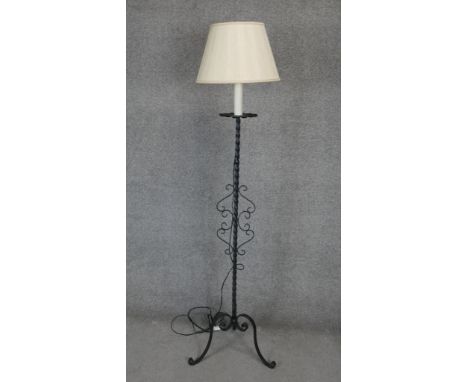 A mid century wrought iron lamp standard on tripod scrolling supports. H.165cm 