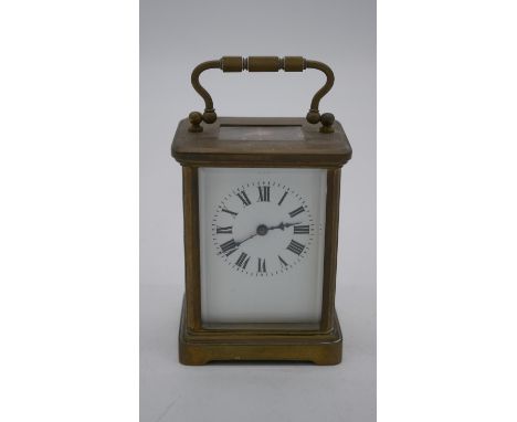 A 1900's brass carriage clock with bevelled glass plates and white enamel dial. H.11 W.8 D.7cm 
