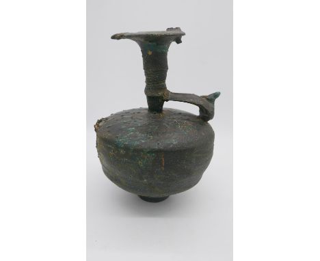 A large green and brown glazed ceramic ewer with mythical animal sculpture that sits on the rim. (damaged) H.40cm 