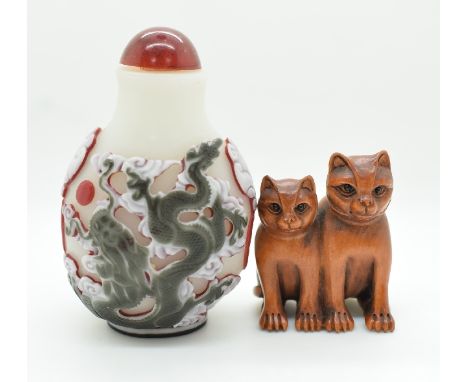 A Chinese glass overlaid scent bottle depicting a dragon and a boxwood netsuke depicting two cats, tallest 9cm&nbsp;