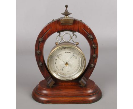 A barometer in cylinder case supported on a horse shoe stand with metal mounts. Maker Curtis of Leicester.  