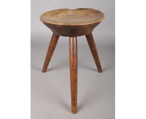 An African hardwood tripod stool with dished seat. Height 35cm, Diameter of seat 26cm.  