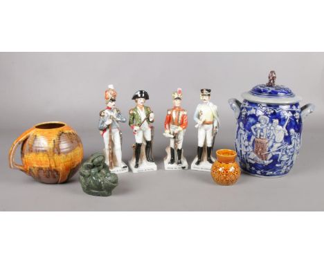 An assortment of ceramics. To include a Westerwald style salt glazed lidded pot, four ceramic soldiers and a Canadian Wolf Or