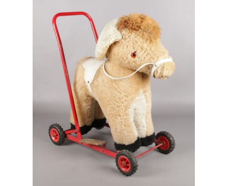 A plush push along donkey, with harness and step plates.  