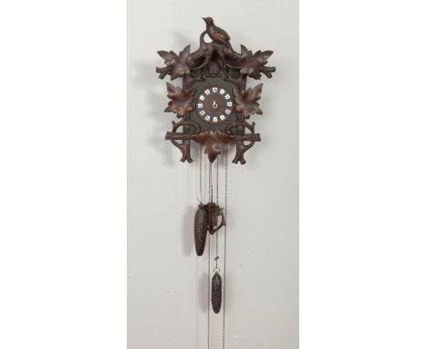 A carved wood black forest style cuckoo clock.  Finial loose and in need of attention, no clock hands.