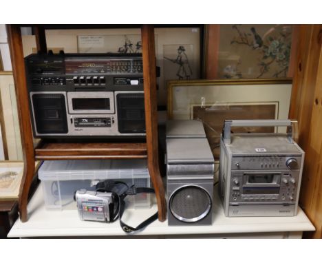 A Sanyo portable mini component system; a Canon digital video camcorder; &amp; a Philips portable radio/cassette recorder. 