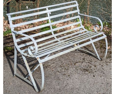 A light grey painted wrought-iron garden bench on shaped supports. 