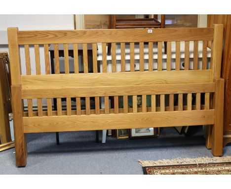 A light oak double bedstead, 160cm long with side-rails, lacking mattress