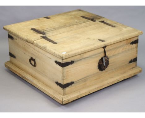 An Eastern-style iron-bound large square wooden storage trunk with a double hinged lift-lid, iron ring side handles, &amp; on