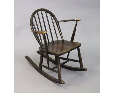 An Ercol spindle-back rocking chair with a hard seat, &amp; on round tapered supports with spindle stretchers. 