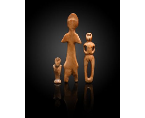 λAn Inuit figural amulet Alaska walrus ivory, with drilled eyes and open arms and legs, 7.1cm high, an Inuit miniature stylis