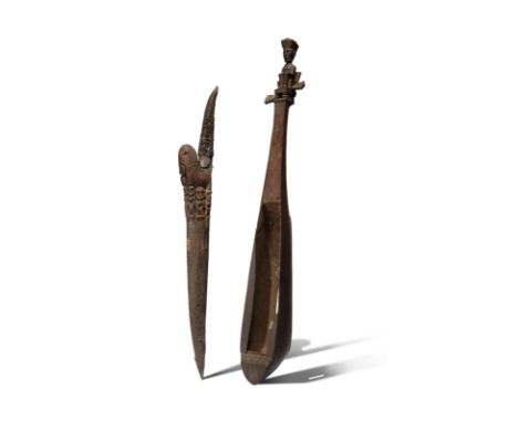 A Batak lute hasapi Sumatra, Indonesia with a carved seated figure finial, 66.6cm long, and a Batak knife with an antler hand