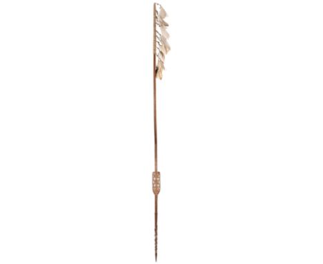 An Asmat spear Irian Jaya, Indonesia with a pointed and barbed tip to carved decoration including a flat panel pierced with s