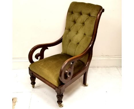 Antique mahogany framed button back library chair, upholstered in a green velvet, with c scroll arms and turned feet ending i