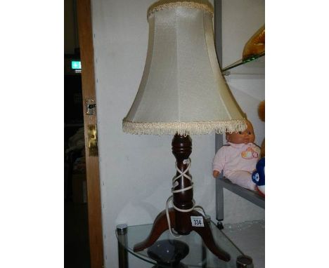 A three legged oak table lamp.
