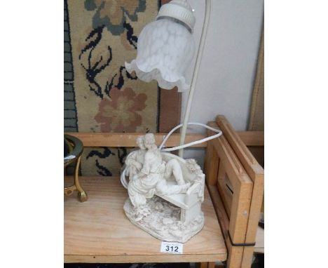 A table lamp with lover's on bench base.