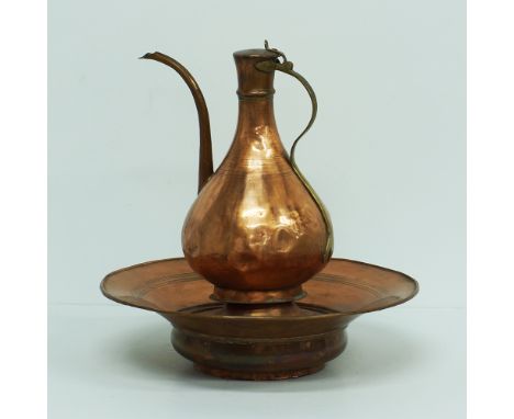An Afgan copper two piece washing set, ewer and basin, jug H31cm, and basin diam.39cm, early / mid 20th century. (2)Provenanc