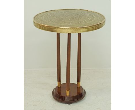 A Gueridon table with a round brass top embossed with Arabesque on a tripod wooden base, probably Liberty's early to mid 20th