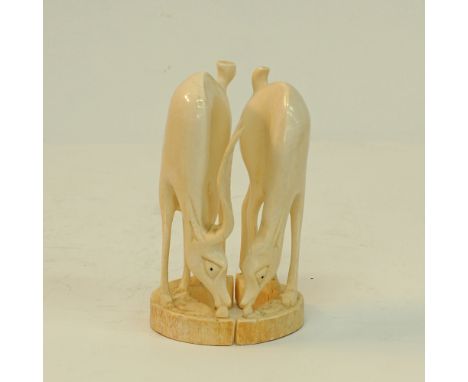 A pair of carved ivory African antelopes one without horns, H17cm, W10cm, approx.weight: 710g. Mid 20th century. (2)Provenanc