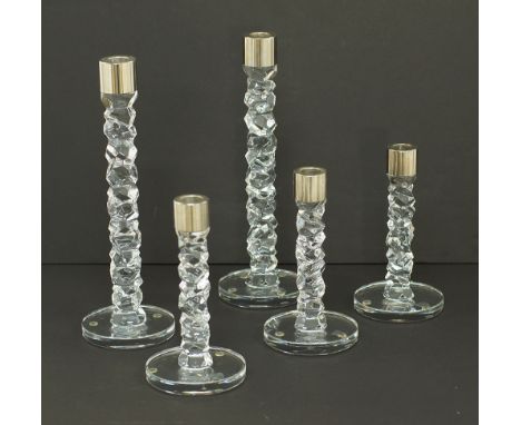 A group of five Orrefors Sweden crystal candlesticks, white metal mounted rings to the rims, H19,5cm and H29,5cm, modern. (5)