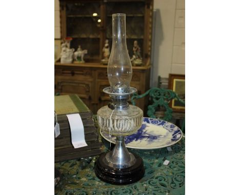 Best British Make oil lamp, with clear glass chimney above a faceted clear glass reservoir, chrome flared stem and ebonised f