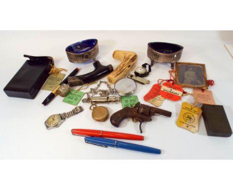 A tray of collectables to include a police whistle, walking cane tops, silver plated salt cellars and old pens etc  