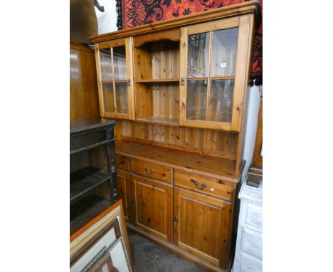 A modern pine kitchen dresser with glazed and shelf back, drawers and cupboards under 55" wide 