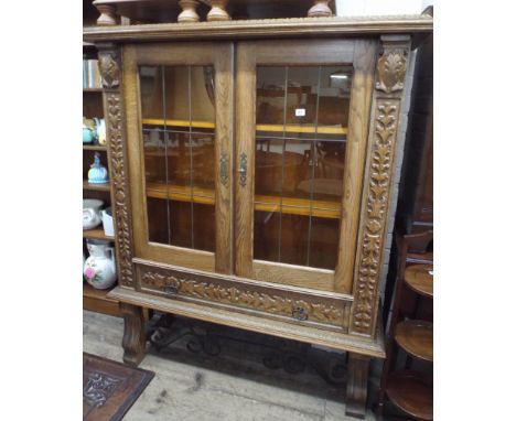 A continental light oak leaded glazed cabinet on stand 