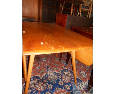 An Ercol honey coloured drop-leaf dining table