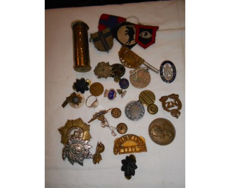 A selection of assorted militaria to include a trench art shell, badges etc