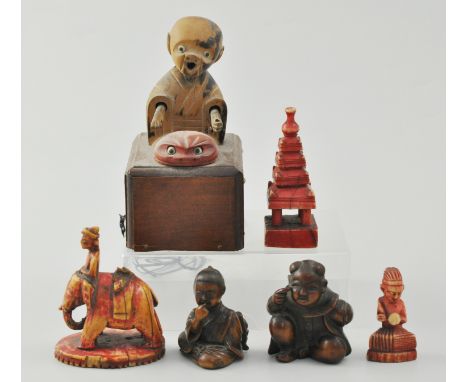 Boxwood Netsuke of a Boy, 4.5cm, another Netsuke of a Boy, signed, three other carvings and a toy.