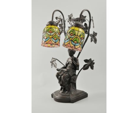 Modern bronzed table lamp, designed with a girl reading a book under a tree, Tiffany style shade, height 52cms.