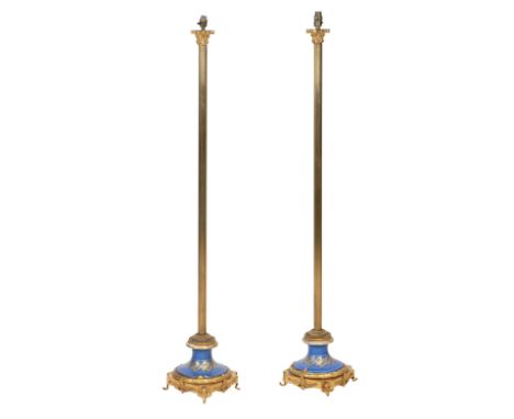 A pair of early 20th century gilt metal and porcelain standard lampsWith single light fitting above a Corinthian column to mo