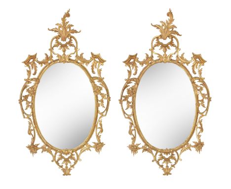 A pair of Chippendale style carved giltwood oval mirrors, early 20th centuryEach with scrolling pierced frame, 60cm wide, 5cm