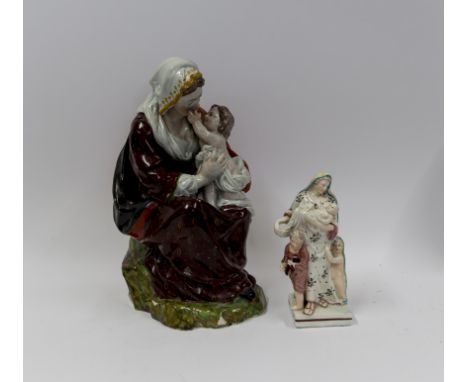 A large pearlware figure of the Madonna and Child and a figure of Charitycirca 1800-15Madonna modelled seated on a rocky outc