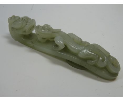 A jade belt hook18th/19th centuryof plae green tone and typically formed with a dragons head and with a chilong 12.5 cms long